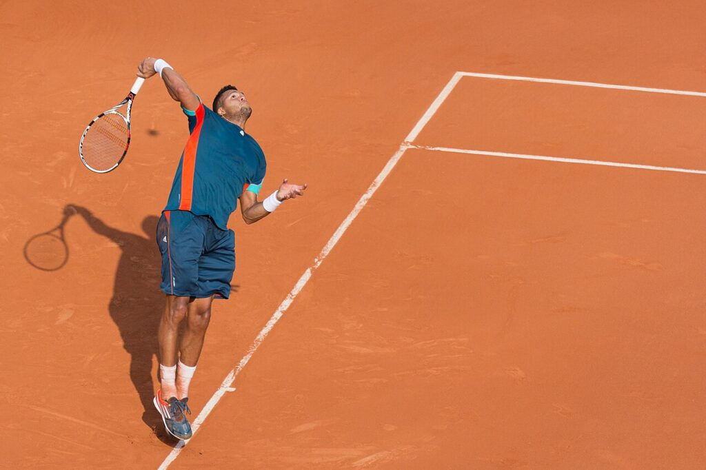 Joueur de tennis au service sur terre battue